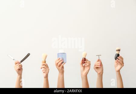 Hands with different tools for shaving on white background Stock Photo