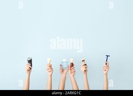 Hands with different tools for shaving on color background Stock Photo