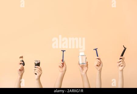 Hands with different tools for shaving on color background Stock Photo