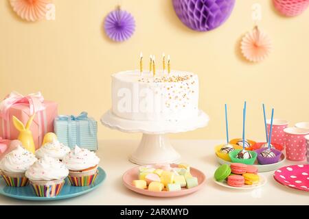Tasty candy bar for Birthday party on table against color background Stock Photo