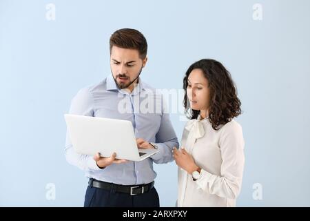 Portrait of emotional business people with laptop on color background Stock Photo
