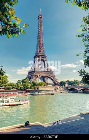 PARIS - SEPTEMBER 20: Tourists rest near the Eiffel Tower on september 20, 2013 in Paris. The Eiffel tower is one of the major tourist attractions of Stock Photo