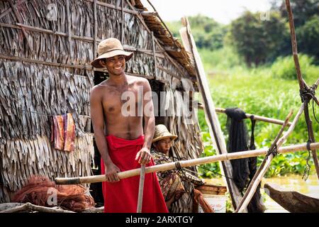 Puok, Siem Reap Province, Cambodia - 4 April 2013: Local Cambodian man at house along Tonle Sap at floating village Stock Photo