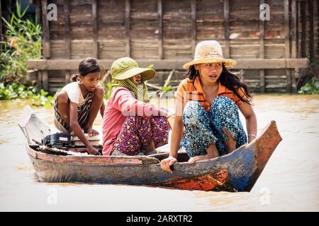 Puok, Siem Reap Province, Cambodia - 4 April 2013: Local Cambodian girls boating along Tonle Sap lake at floating village Stock Photo