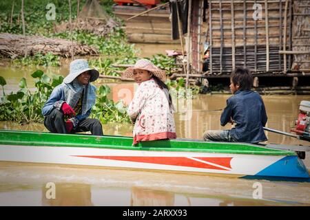 Puok, Siem Reap Province, Cambodia - 4 April 2013: Local Cambodian people boating along Tonle Sap lake at floating village Stock Photo