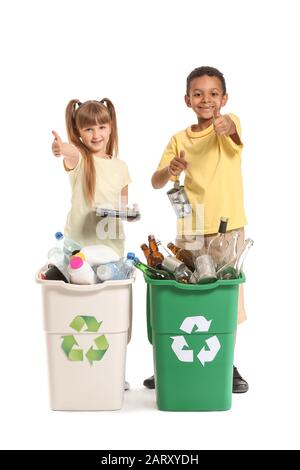 Little children and containers with trash on white background. Concept of recycling Stock Photo