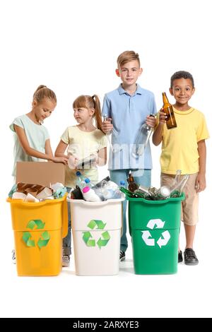 Little children and containers with trash on white background. Concept of recycling Stock Photo