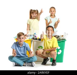 Little children and containers with trash on white background. Concept of recycling Stock Photo