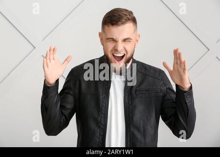 Screaming young man on grey background Stock Photo