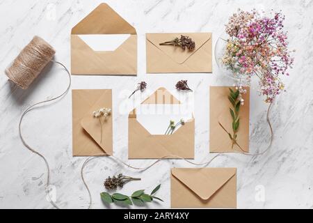 Invitations with envelopes and floral decor on white background Stock Photo