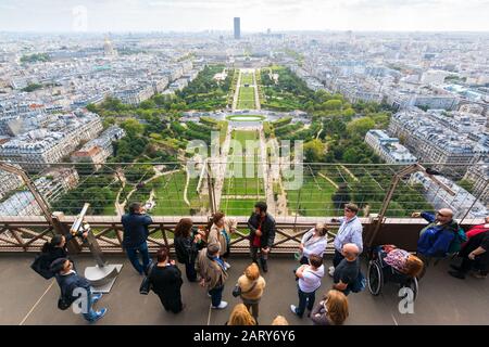 PARIS - SEPTEMBER 20, 2013: Tourists are on the observation deck of the Eiffel Tower. The Eiffel tower is one of the major tourist attractions of Fran Stock Photo