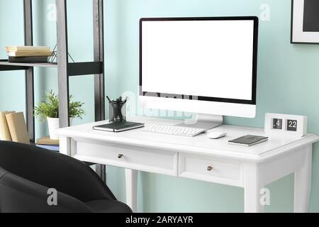 Comfortable workplace with modern computer near color wall Stock Photo