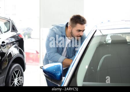 Man choosing new car in salon Stock Photo