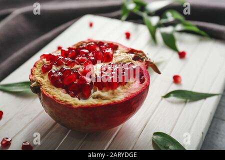 Tasty pomegranate on wooden board Stock Photo