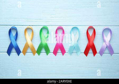 Different awareness ribbons on color wooden background Stock Photo