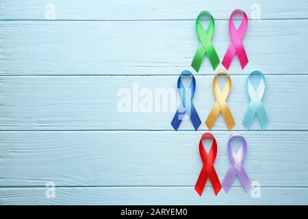 Different awareness ribbons on color wooden background Stock Photo