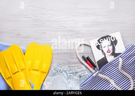 Set of beach accessories with makeup cosmetics on white wooden background Stock Photo