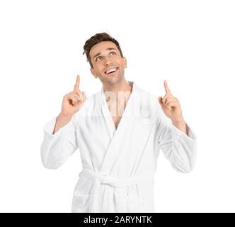 Handsome man in bathrobe pointing at something on white background Stock Photo