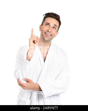 Handsome man in bathrobe pointing at something on white background Stock Photo