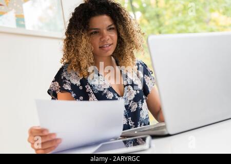 Smiling woman working on laptop Stock Photo