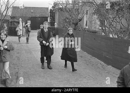 Staphorst  Outbreak polio in Staphorst. Children on the street on the way to school, boy (m) sticks out his tongue. Next to him girl in costume Date: 15 March 1971 Location: Overijssel, Staphorst Keywords: village images, children, schools Stock Photo