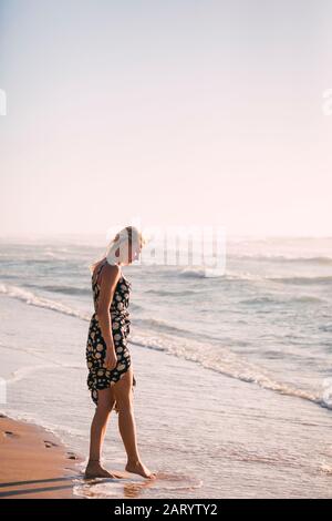Woman wearing black dress on beach Stock Photo