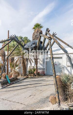 A gigantic spider sculpture made with welded parts including a Volkswagen Beetle stands outside of a business along Indian Canyon Rd in Palm Springs. Stock Photo