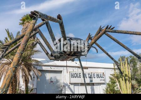 A gigantic spider sculpture made with welded parts including a Volkswagen Beetle stands outside of a business along Indian Canyon Rd in Palm Springs. Stock Photo