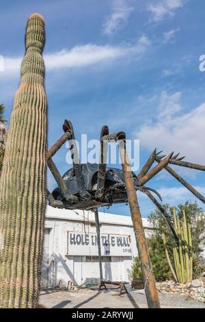 A gigantic spider sculpture made with welded parts including a Volkswagen Beetle stands outside of a business along Indian Canyon Rd in Palm Springs. Stock Photo