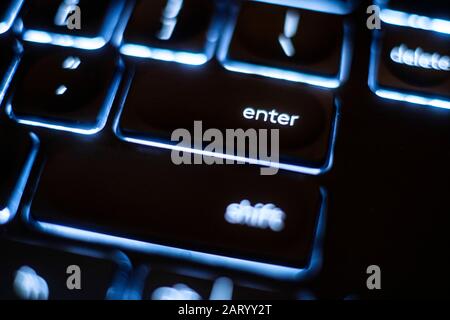 Illuminated 'enter' key on keyboard Stock Photo