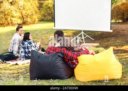 Friends watching movie in outdoor cinema Stock Photo