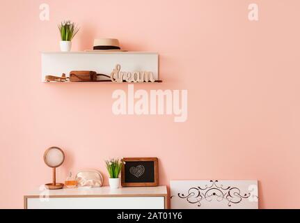 Shelf and chest of drawers with female accessories in room Stock Photo