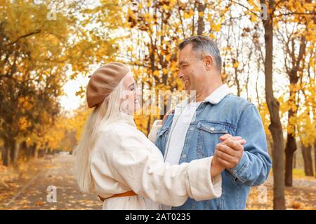Happy mature couple dancing in autumn park Stock Photo