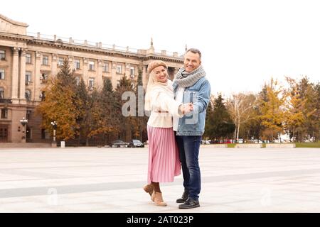 Happy mature couple dancing outdoors on autumn day Stock Photo