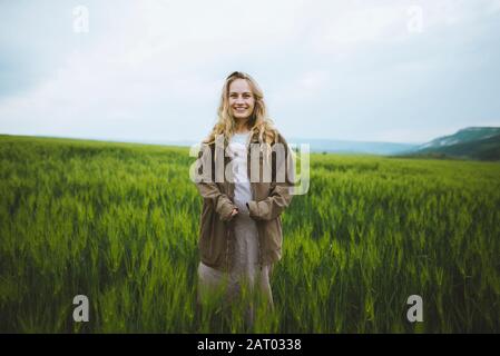 Smiling woman wearing jacket in field in Crimea, Ukraine Stock Photo