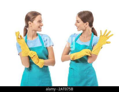 Female janitors putting on rubber gloves against white background Stock Photo