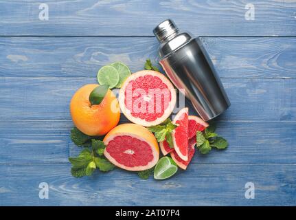Fresh grapefruits, lime and shaker on table Stock Photo