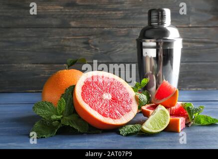Fresh grapefruits, lime and shaker on table Stock Photo
