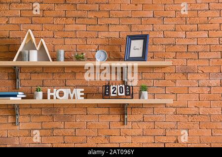 Shelves with decor hanging on brick wall Stock Photo