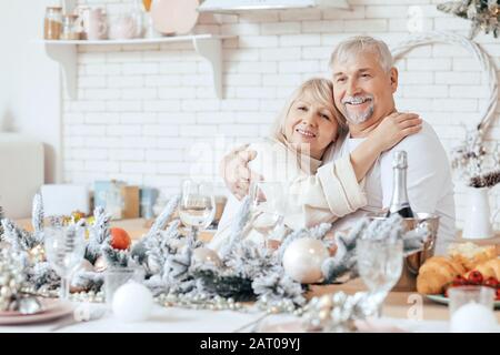 Happy mature couple on Christmas eve in kitchen Stock Photo