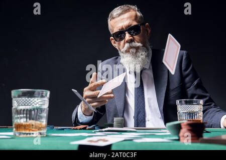 Mature businessman playing in casino Stock Photo