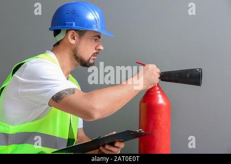 Fire safety specialist inspecting extinguisher Stock Photo