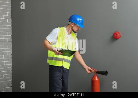 Fire safety specialist inspecting extinguisher Stock Photo