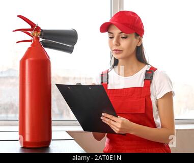 Fire safety specialist inspecting extinguisher Stock Photo