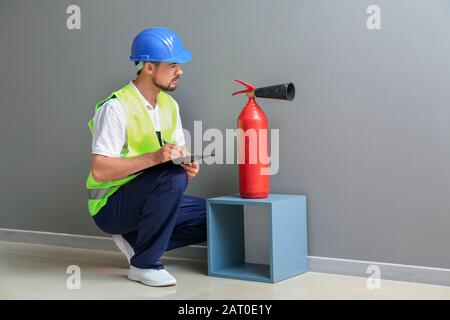 Fire safety specialist inspecting extinguisher Stock Photo
