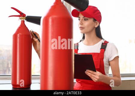 Fire safety specialist inspecting extinguisher Stock Photo