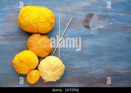 Knitting yarns and needles on wooden background Stock Photo