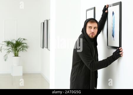 Thief stealing picture from art gallery Stock Photo