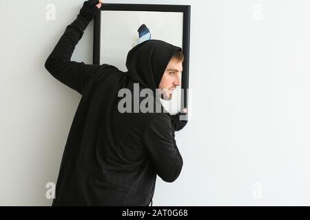 Thief stealing picture from art gallery Stock Photo