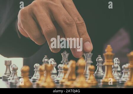 Chess game on chess board behind business man background. Business concept  to present financial information and marketing strategy analysis. Investmen  Stock Photo - Alamy